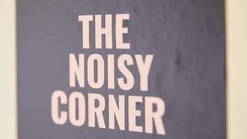 Um letreiro com o texto 'THE NOISY CORNER'.