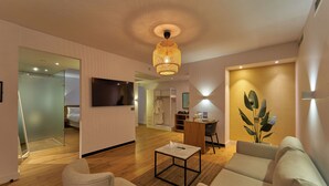 A modern living room with a wooden floor, a sofa, a coffee table, and a TV mounted on the wall. - New President Hotel Cairo (Cairo)