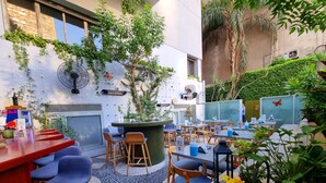 An outdoor café with tables and chairs, surrounded by greenery and decorative elements. - New President Hotel Cairo (Cairo)