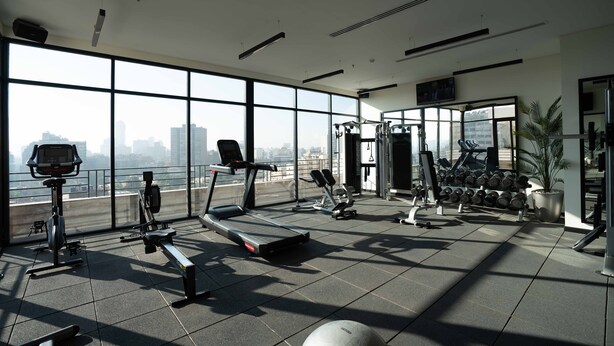 A modern gym with various exercise equipment, large windows offering a city view, and a clean, spacious layout. - New President Hotel Cairo (Cairo)
