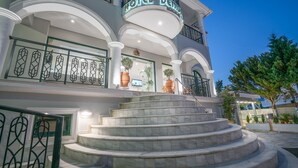 A hotel entrance with a grand staircase, large potted plants, and a clear sky. - Denise Beach Hotel (Zakynthos)