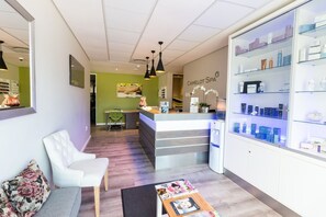 A reception area with a counter, seating, and a display of products. - Royal St. Andrews Hotel, Conference Centre & Spa (Port Alfred)