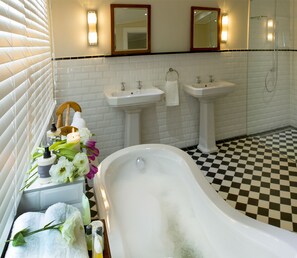 A bathroom with a checkered floor, two sinks, a bathtub, and a mirror above the sinks. - Royal St. Andrews Hotel, Conference Centre & Spa (Port Alfred)