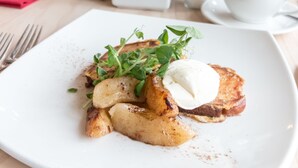 Una mesa con un plato de comida, una taza de café y varios condimentos.