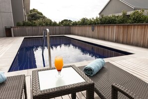 A rectangular swimming pool with a glass table and chairs in the foreground. - Royal St. Andrews Hotel, Conference Centre & Spa (Port Alfred)