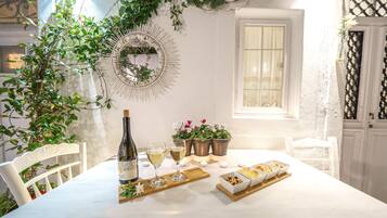 A table set with a bottle of wine, glasses, and a tray with food items.
