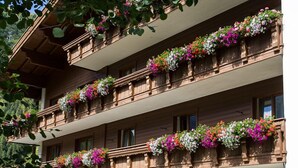 Un edificio de varios pisos con balcones decorados con flores coloridas.
