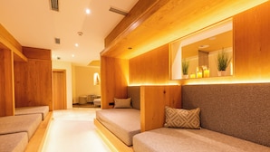 Una habitación de hotel con paneles de madera, un espejo grande y un sofá con cojines estampados.