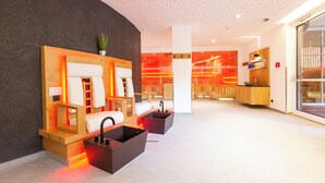 Un moderno espacio de spa con mostrador de recepción, zona de estar y un amplio ventanal.