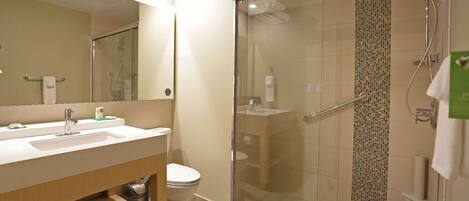 A modern bathroom with a glass-enclosed shower, a sink, and a toilet.