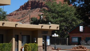 A building named 'LOBBY' with a sign for 'Adobe Realty' and a mountain in the background. - Redrock Country Inn (Kanab)