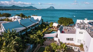 Un resort con varias construcciones, piscina y vista al océano.