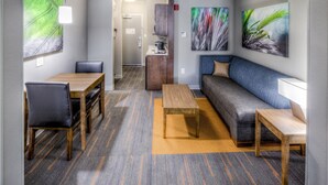 A modern hotel room with a dining area, a sofa, and a small table. - Holiday Inn Express & Suites Cleveland West - Westlake by IHG (Westlake)