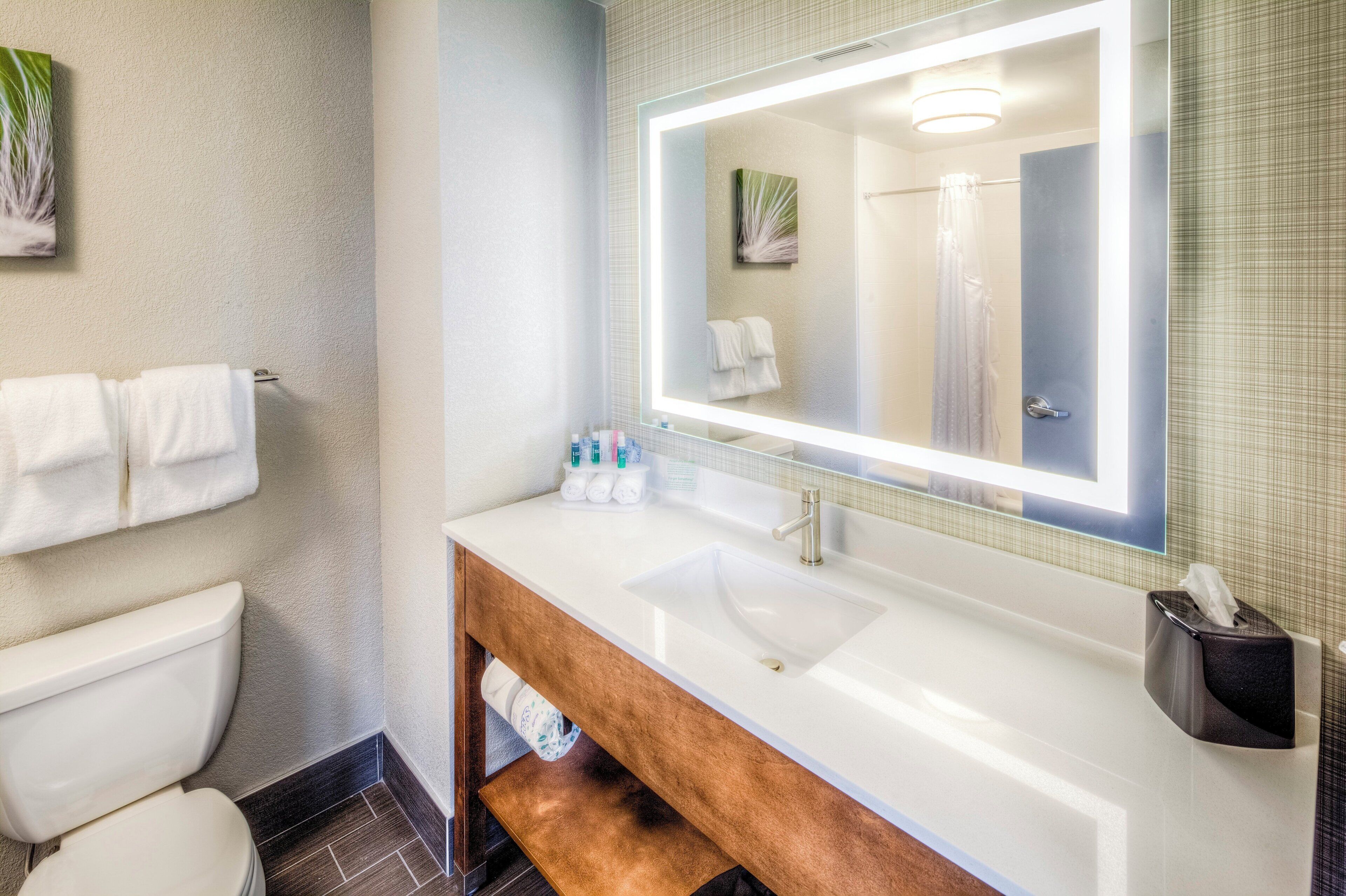 A bathroom with a white sink, a mirror, and a towel rack.