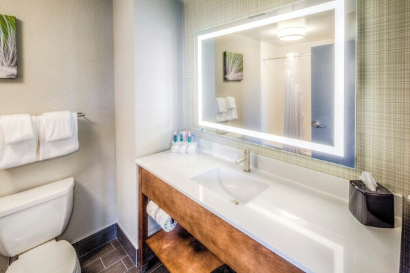 A bathroom with a white sink, a mirror, and a towel rack.
