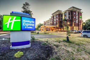 A Holiday Inn Express & Suites sign with a brick building in the background. - Holiday Inn Express & Suites Cleveland West - Westlake by IHG (Westlake)