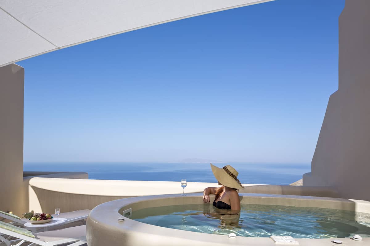 Una persona en un jacuzzi con vista al océano.