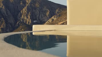 A reflective pool with a mountain backdrop and a plain wall.