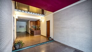 A modern interior with a wooden staircase, a reception desk, and a hallway leading to a room. - Maison Bianca (Florence)