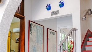 Un hall de hotel con una escalera, un mapa en la pared y un cartel que indica que el establecimiento no admite fumar.