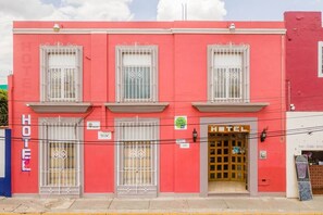 Stylish two-story building with a bright red facade and a large entrance.