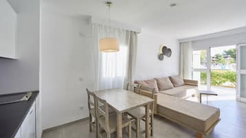 Una sala de estar moderna con una mesa de comedor, sofá y un amplio ventanal con vistas al exterior.
