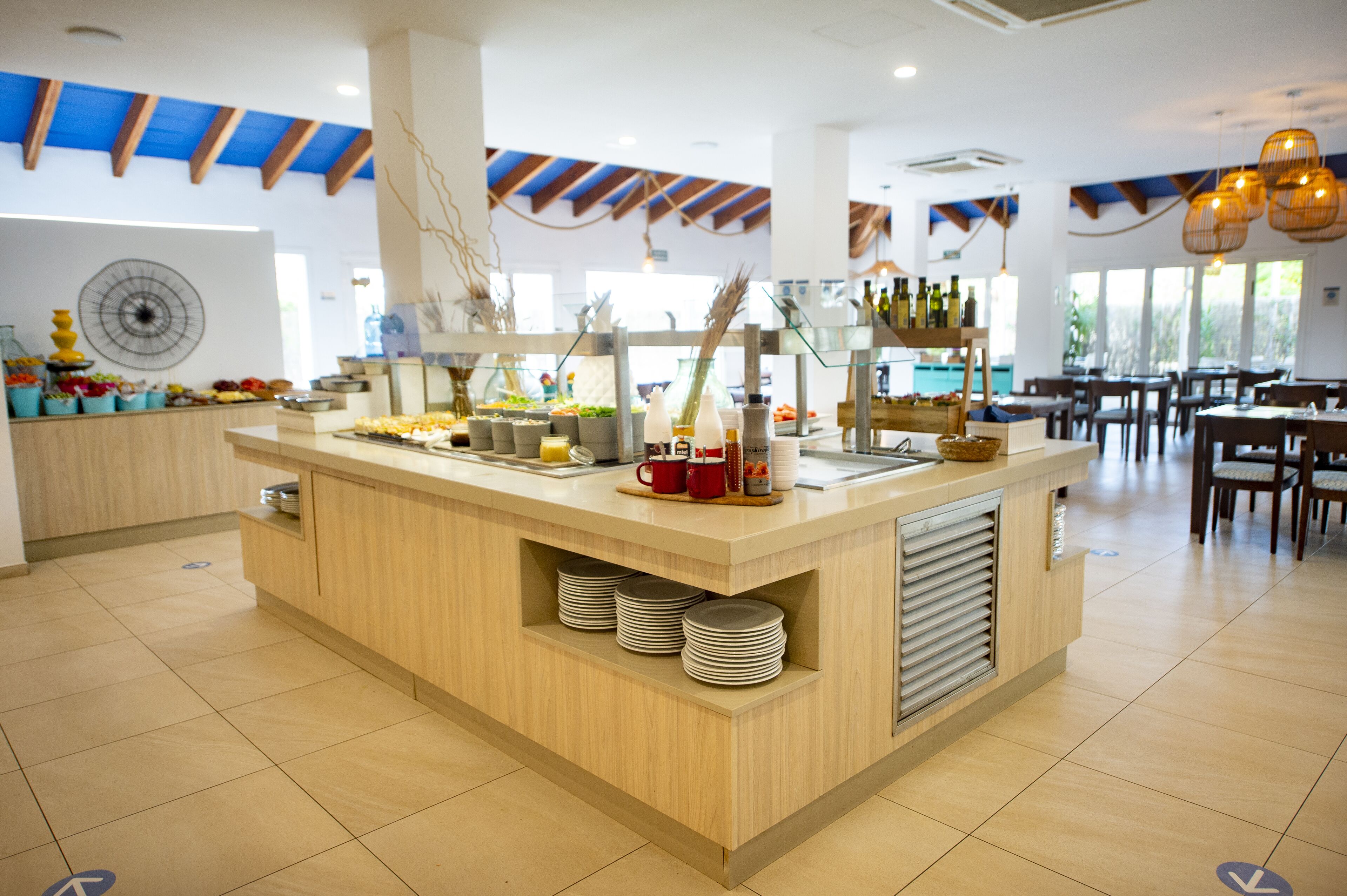 A buffet area with a wooden counter, plates, and various food items.