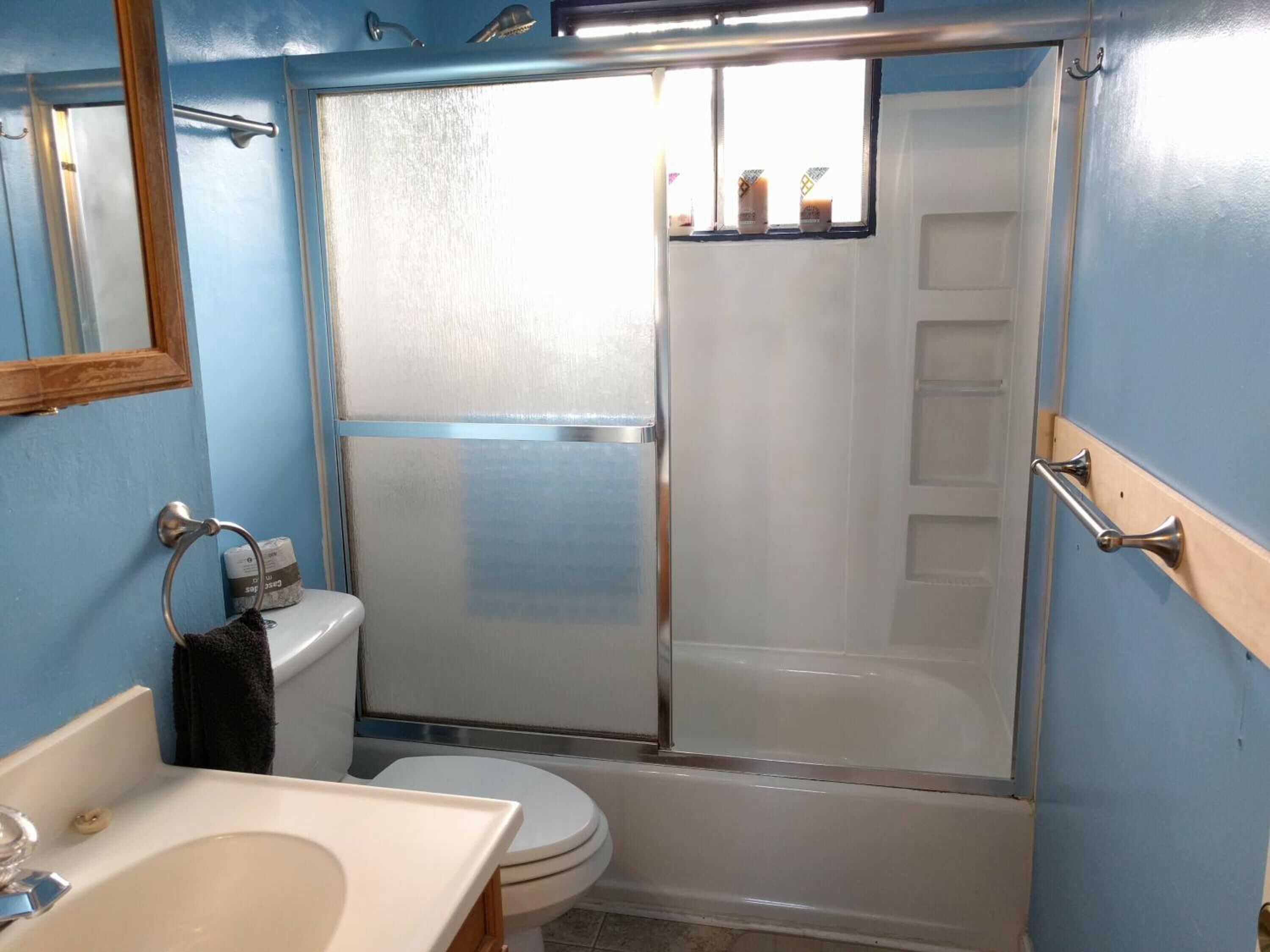 Un baño con ducha, inodoro y lavabo.