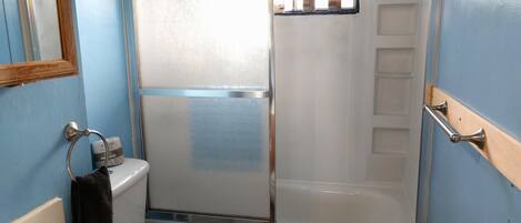 Un baño con ducha, inodoro y lavabo.