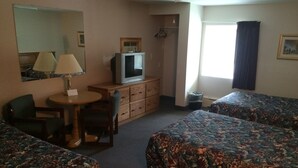 A hotel room with two beds, a desk, a chair, a dresser, a television, and a window with curtains. - Fern Ridge Motel (Blakeslee)