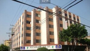 Un hotel de varios pisos con un cartel que anuncia un restaurante y bar en la planta baja.