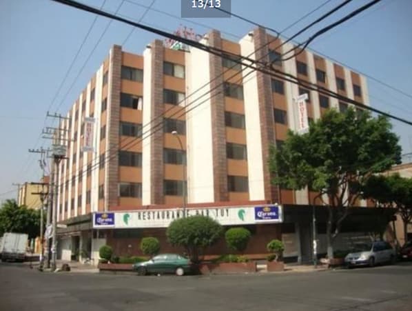Un hotel de varios pisos con un cartel que anuncia un restaurante y bar en la planta baja.