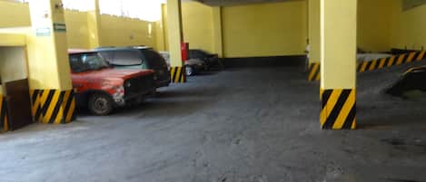 Un aparcamiento con pilares amarillos y barreras con rayas negras y amarillas.