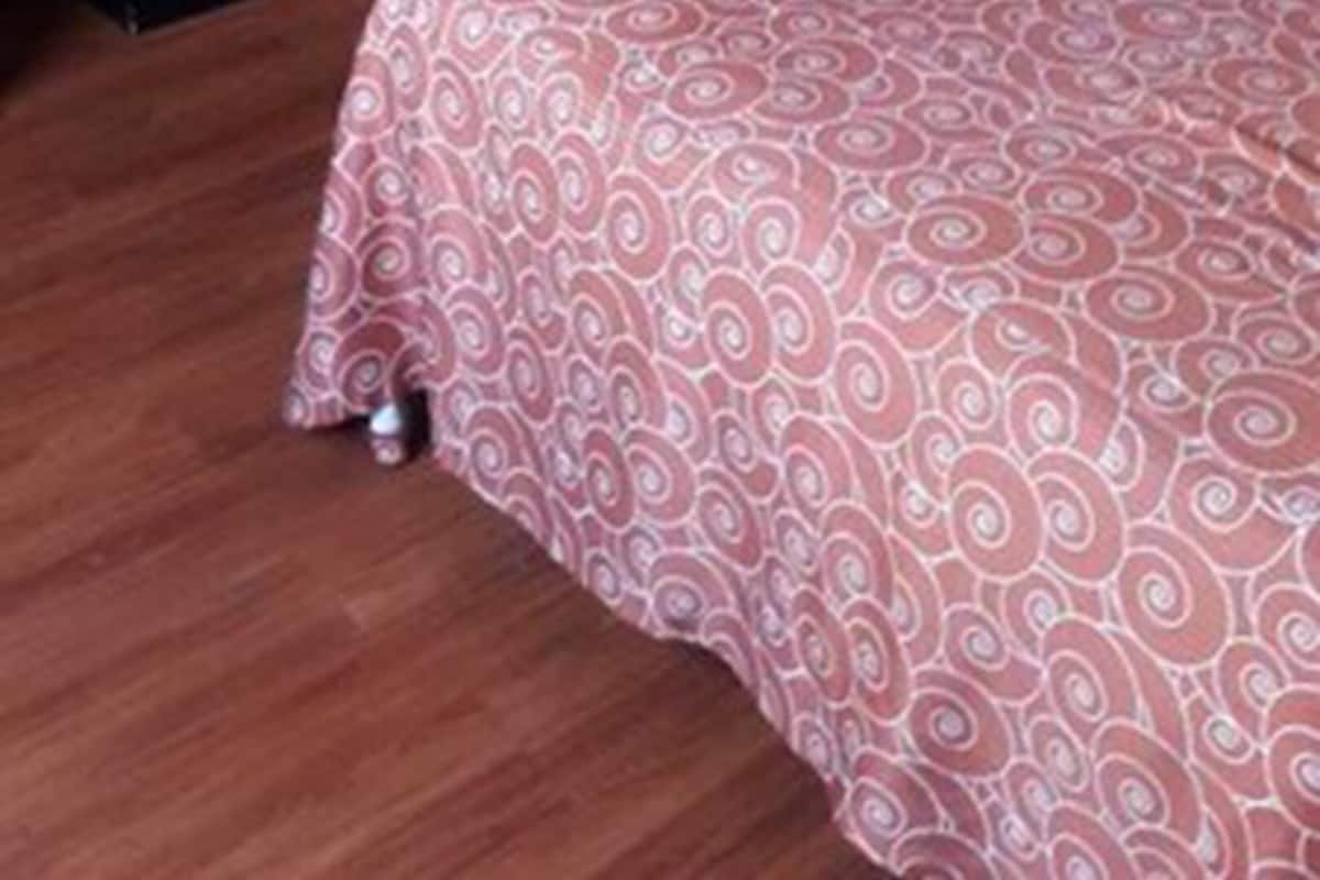 Een hotelkamer met twee bedden, een bureau en een kledingkast.