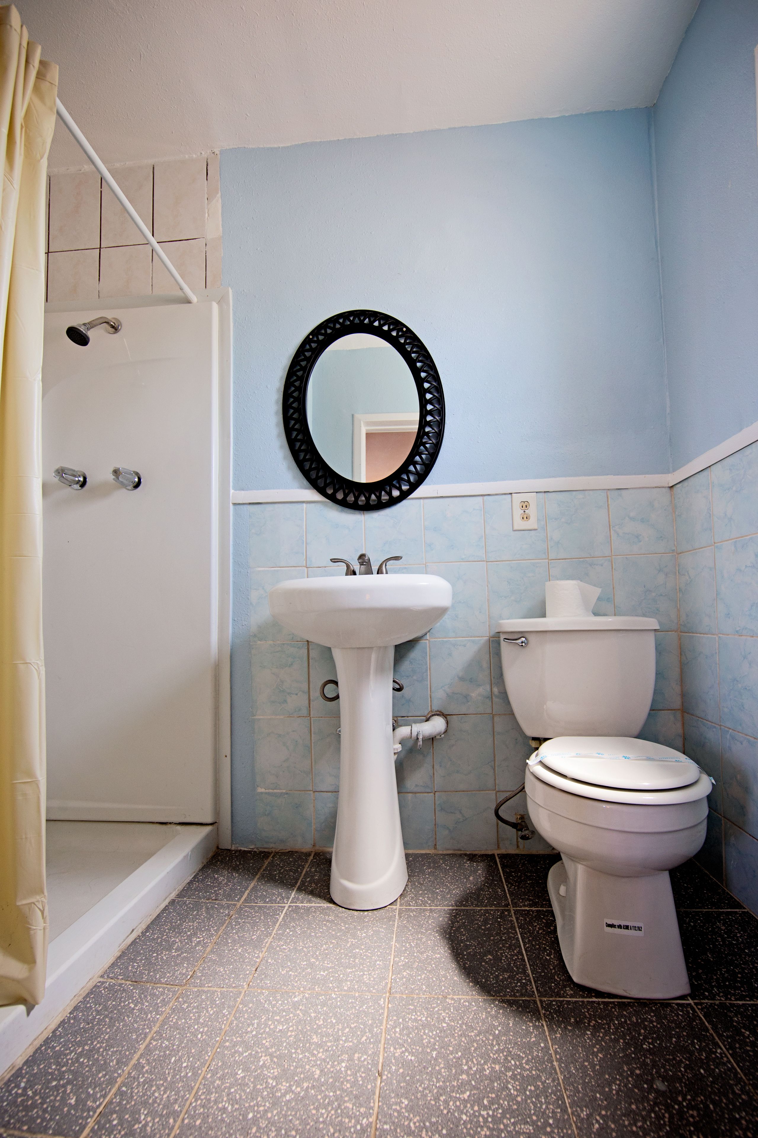 Une salle de bain avec une douche, un lavabo et des toilettes.
