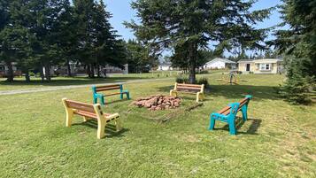 Relax in a serene outdoor space surrounded by mature trees and a well-maintained lawn.