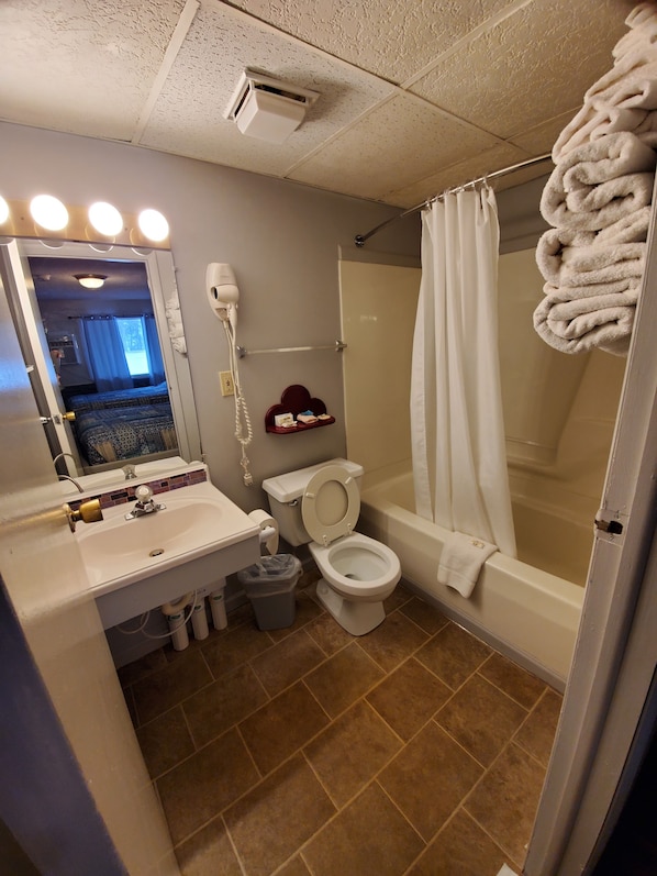 Standard Single Room, 2 Queen Beds, Ground Floor | Bathroom | Combined shower/tub, hair dryer, towels, soap