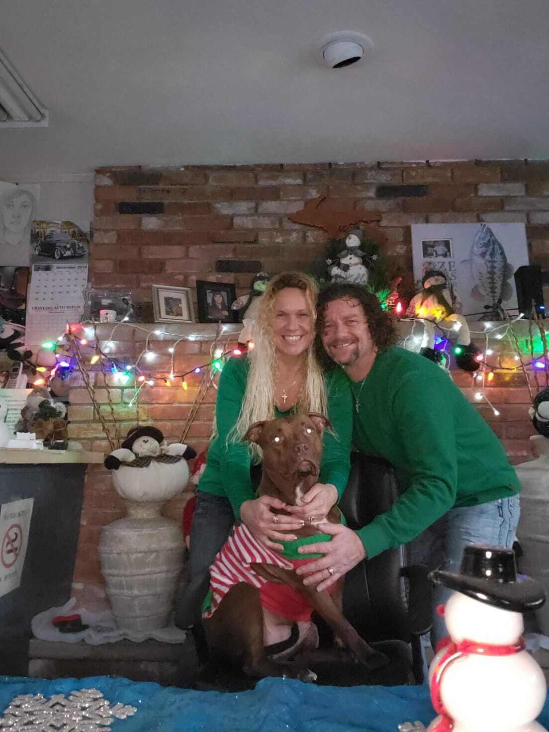 A room with brick walls, a fireplace, and Christmas decorations including lights and a snowman.