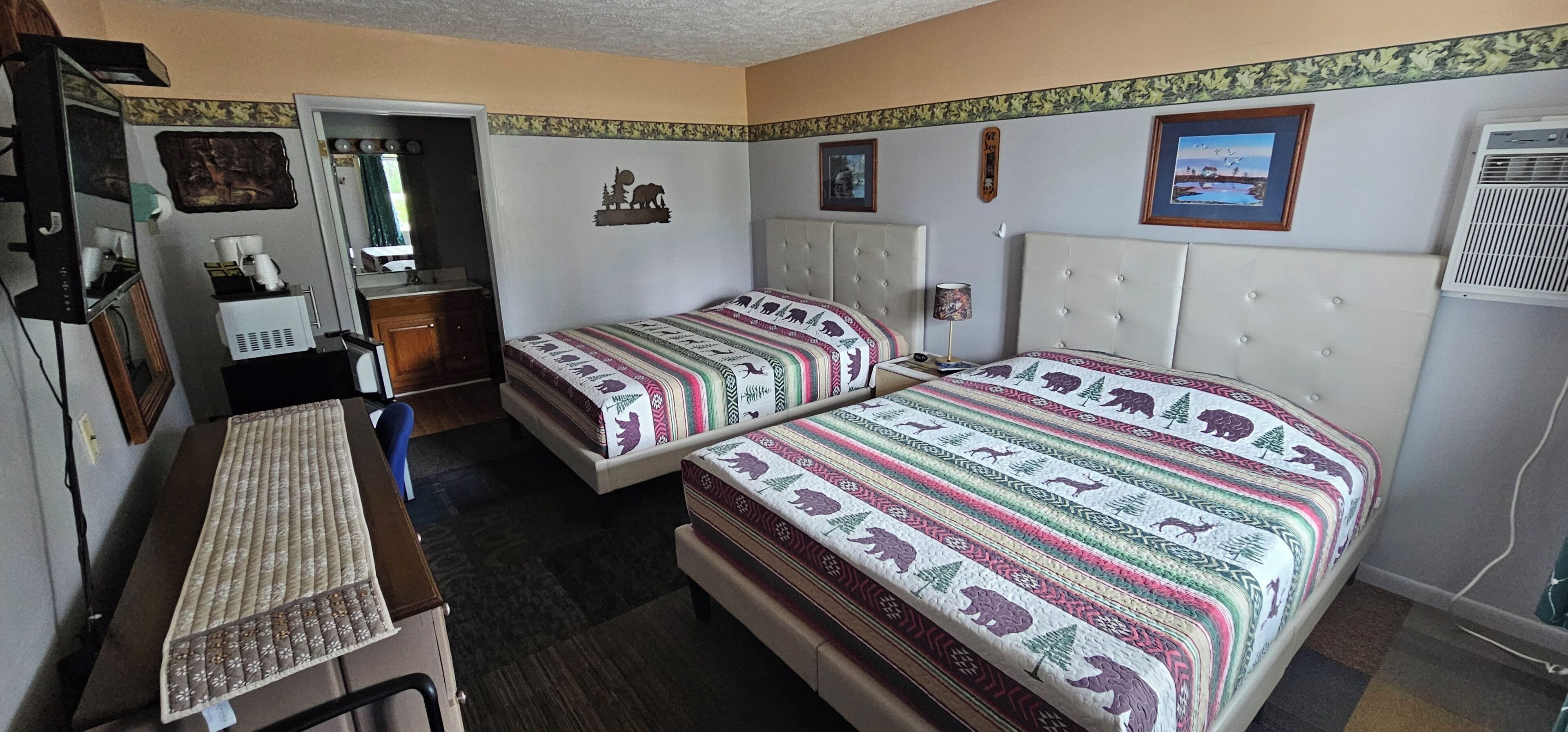 A room with two beds, a desk, and a chair.