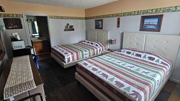 A room with two beds, a desk, and a chair.