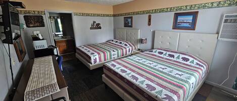 A room with two beds, a desk, and a chair.