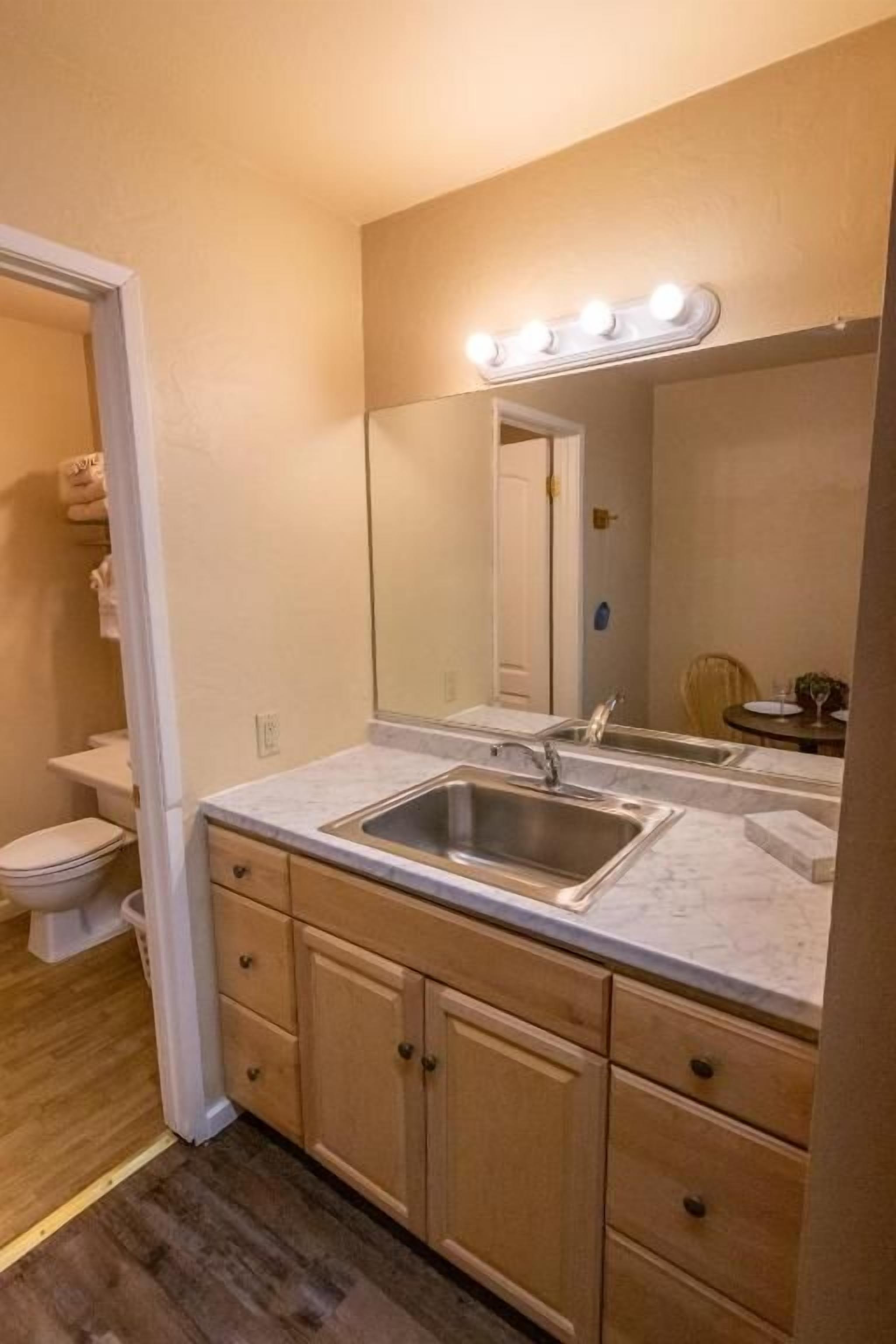 Une salle de bain avec un lavabo, un miroir et un meuble-lavabo.
