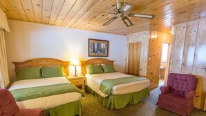 A room with two beds, a ceiling fan, a painting, and a chair. - June Lake Motel (June Lake)