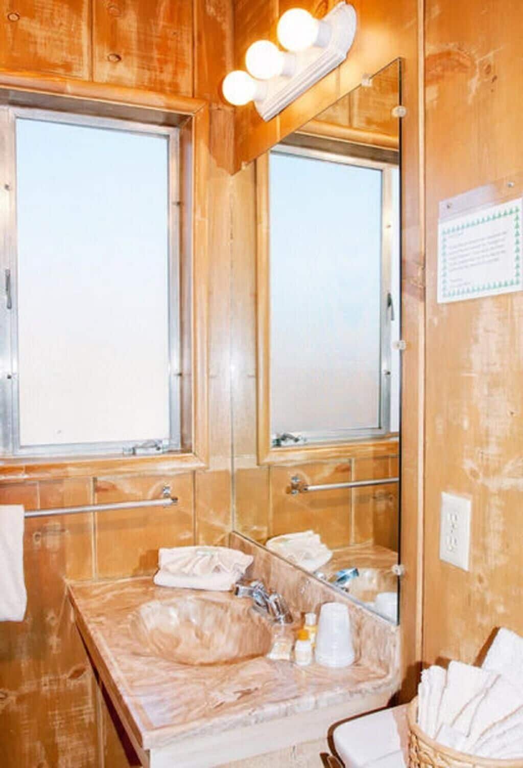 A bathroom with two sinks, a mirror, and a window.