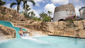 Una piscina al aire libre, camas de piscina con cargo, sombrillas