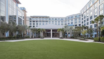 Un hotel moderno con un cortile centrale, diversi piani e un'area d'ingresso coperta.