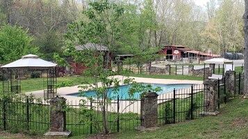 Una piscina al aire libre, sillones reclinables de piscina