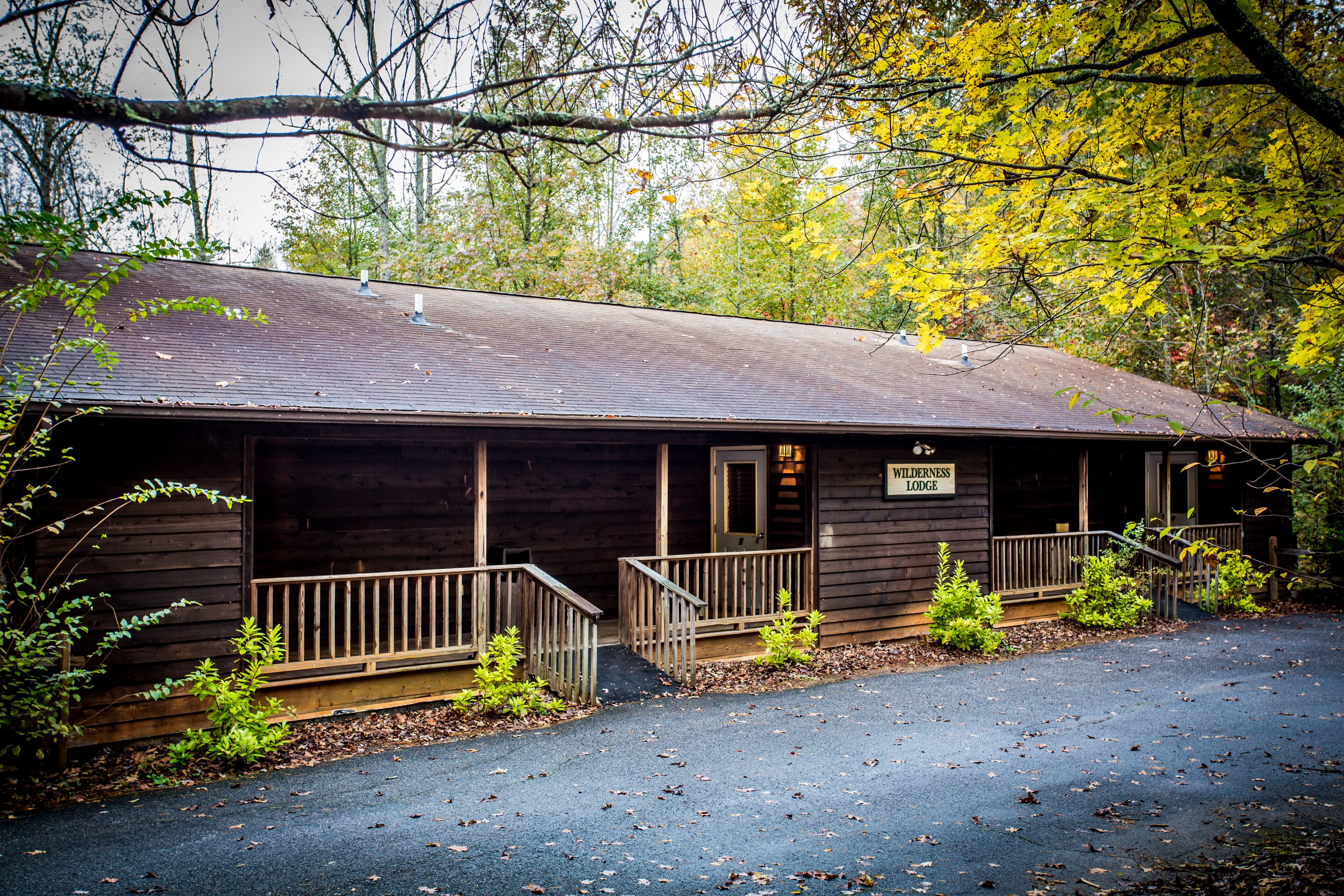 A wooden lodge with a porch and a sign reading "Wilderness Lodge".