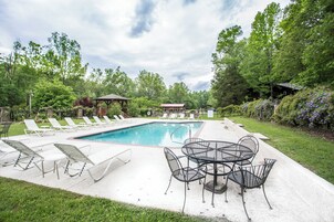 Una piscina al aire libre, sillones reclinables de piscina