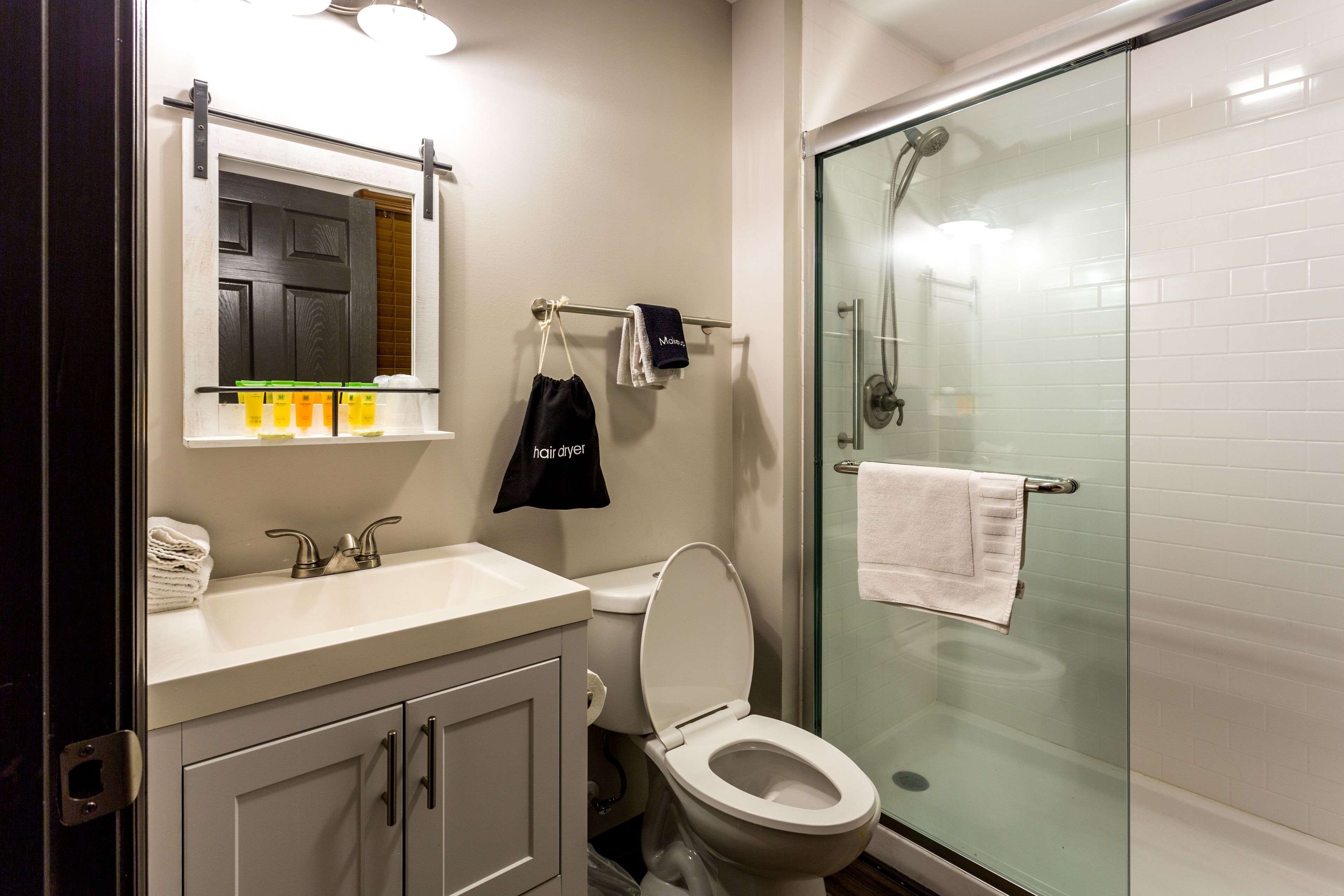 Un bagno moderno con box doccia in vetro, lavandino bianco e servizi igienici.